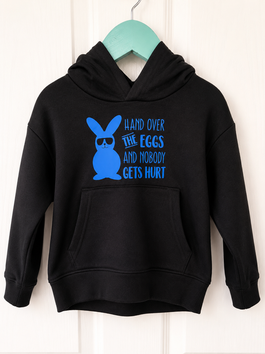 Hand Over The Eggs black kids hoodie on a teal hanger